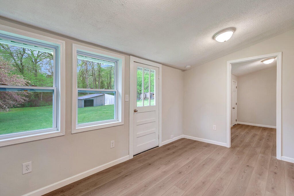 183 Earl Ezell Road Spring City, TN 37381 - Photo 17 of 30 a view of an empty room with wooden floor and a window