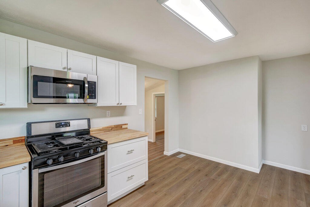 183 Earl Ezell Road Spring City, TN 37381 - Photo 9 of 30 a kitchen with granite countertop white cabinets and stainless steel appliances