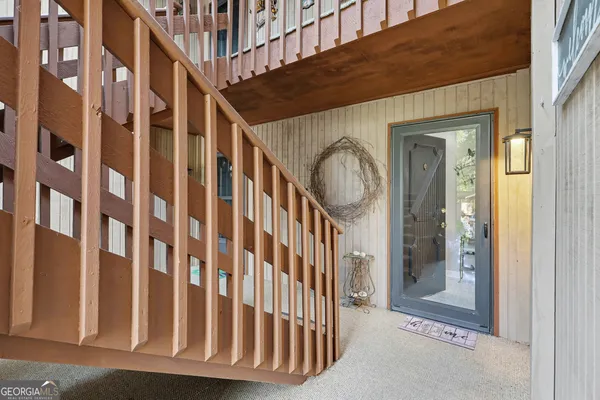 a view of a hallway with wooden floor and a bathroom