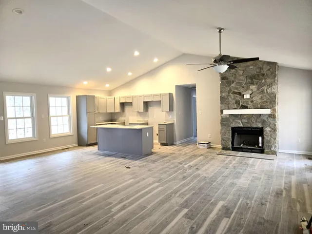 a view of kitchen and empty room with wooden floor kitchen view