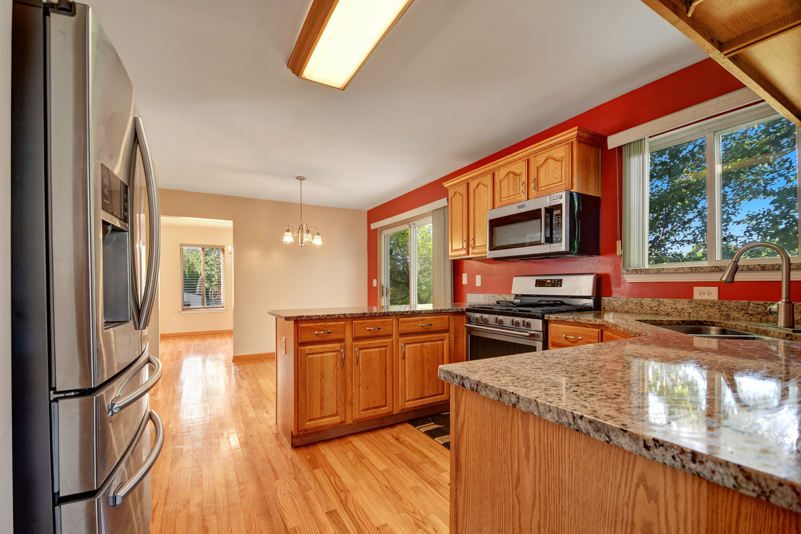 428 Rachel Circle Romeoville, IL 60446 - Photo 14 of 26 a kitchen with stainless steel appliances granite countertop a refrigerator a stove top oven a sink dishwasher and wooden cabinets with wooden floor
