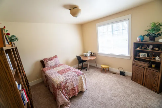 a bedroom with bed and a large window