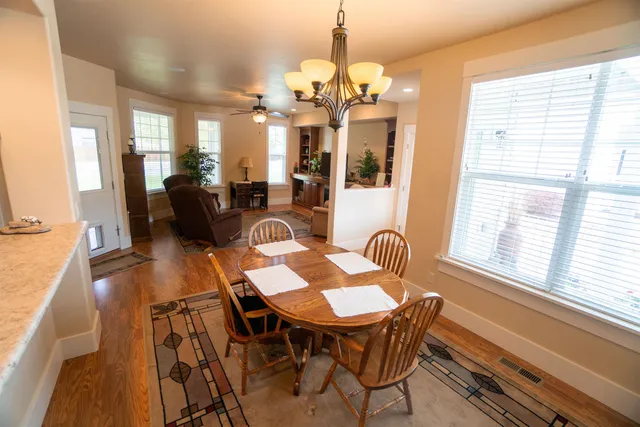 a view of a dining room with furniture a chandelier and wooden floor