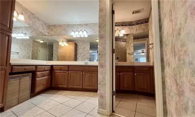 a bathroom with a sink a large mirror and a glass door shower