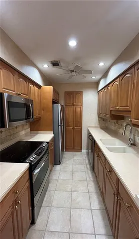 a large kitchen with a large counter top stainless steel appliances and cabinets
