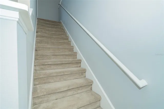 an empty room with wooden floor closet and windows