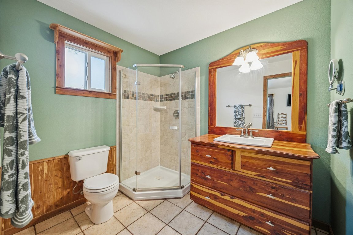 3502 1869th Ranch Liberty Hill, TX 78642 - Photo 15 of 18 a bathroom with a granite countertop toilet a mirror and shower