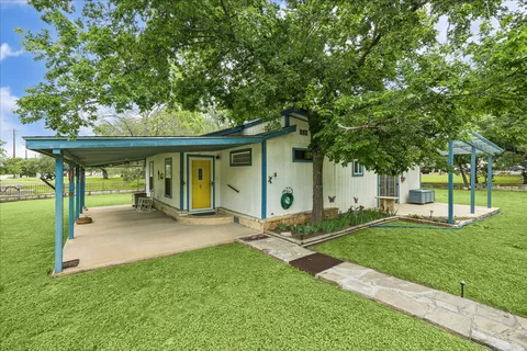 a view of a house with a yard and sitting area