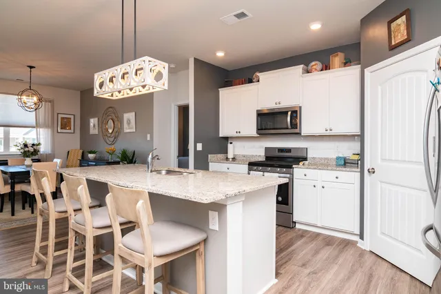 a open kitchen with stainless steel appliances granite countertop a stove refrigerator and a sink