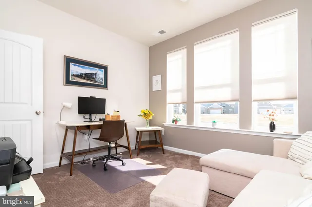 a view of a livingroom with workspace and a window