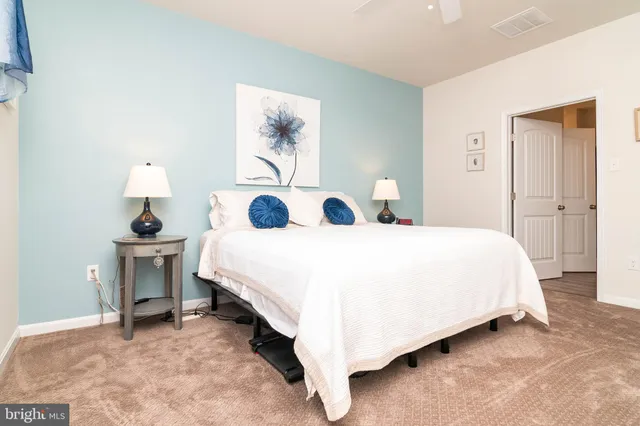 a spacious bedroom with a bed and a lamp