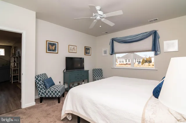 a bedroom with a bed couches chair and a large mirror