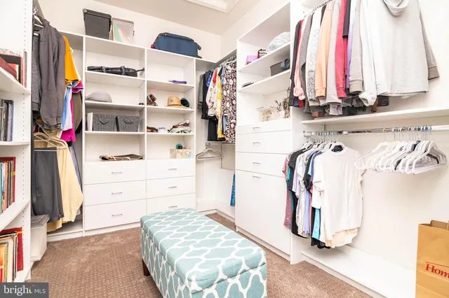 a view of walk in closet with clothes and shoes