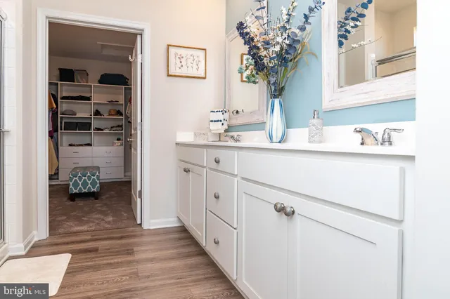 a hallway with white cabinets and chandelier