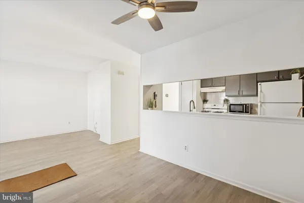 a view of kitchen with stainless steel appliances refrigerator stove and wooden floor