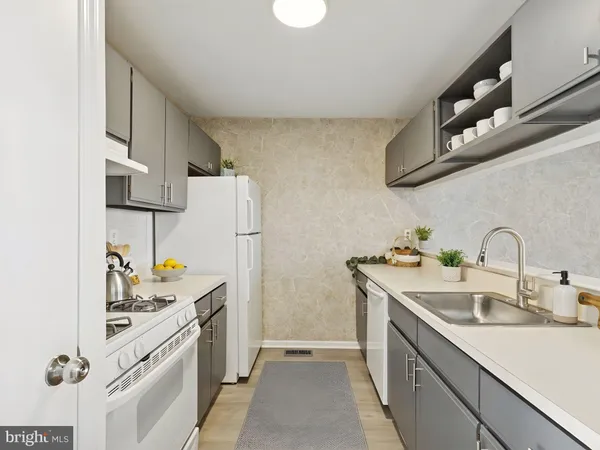 a kitchen with a sink a refrigerator and cabinets