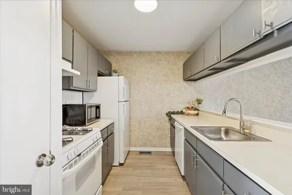 a kitchen with stainless steel appliances a sink stove and refrigerator