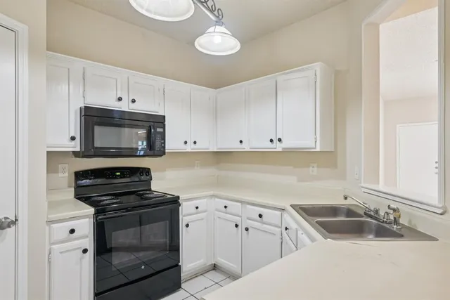 a kitchen with white cabinets and a sink
