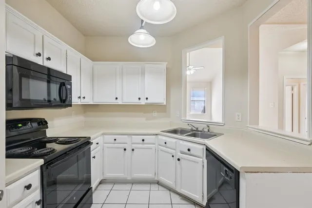an empty room with windows and ceiling fan