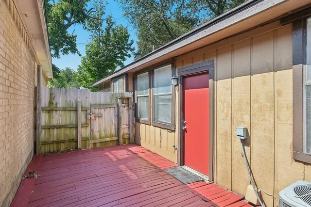 a view of a backyard with large trees and wooden fence