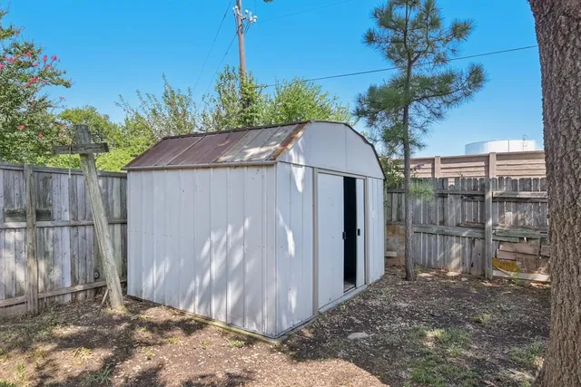 a view of a backyard with wooden fence