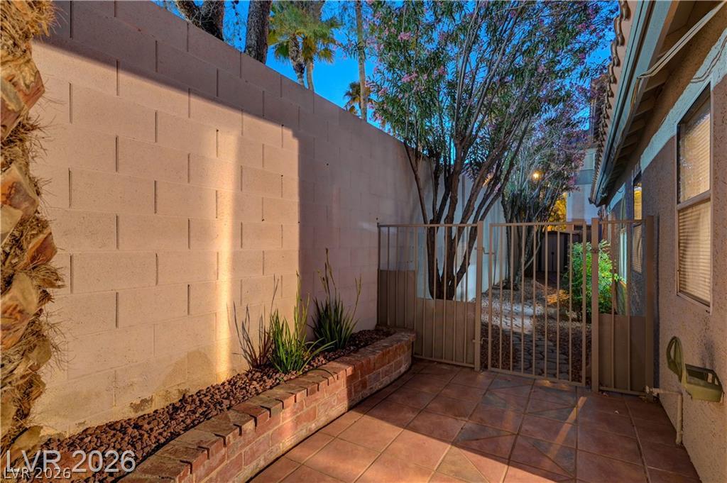 2283 Ramsgate Drive Henderson, NV 89074 - Photo 46 of 51 Tiled private patio area enclosed by high masonry walls and a secure metal gate.