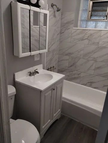 a bathroom with a sink vanity mirror and toilet