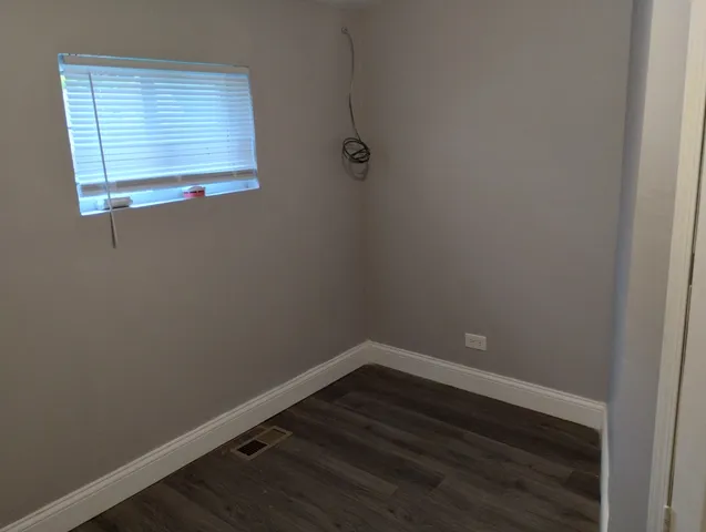 a view of a small space with wooden floor and a window