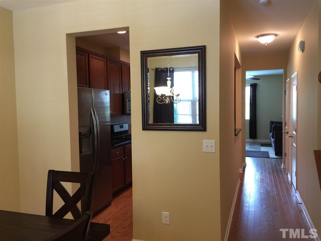 721 Wickham Ridge Road Apex, NC 27539 - Photo 2 of 25 a view of a hallway with wooden floor and a livingroom with furniture