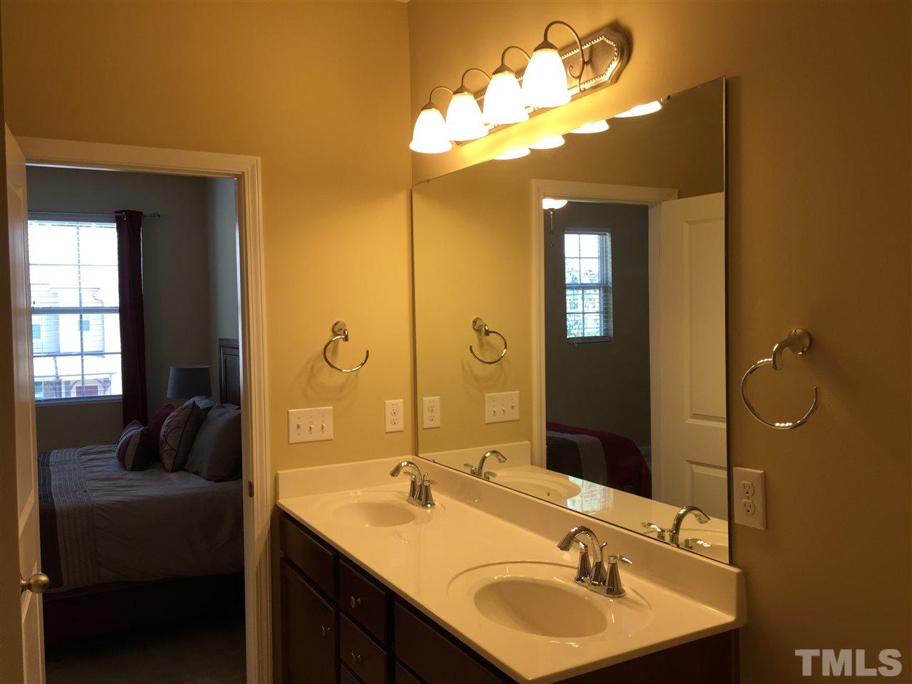 721 Wickham Ridge Road Apex, NC 27539 - Photo 13 of 25 a bathroom with a double vanity sink and a mirror