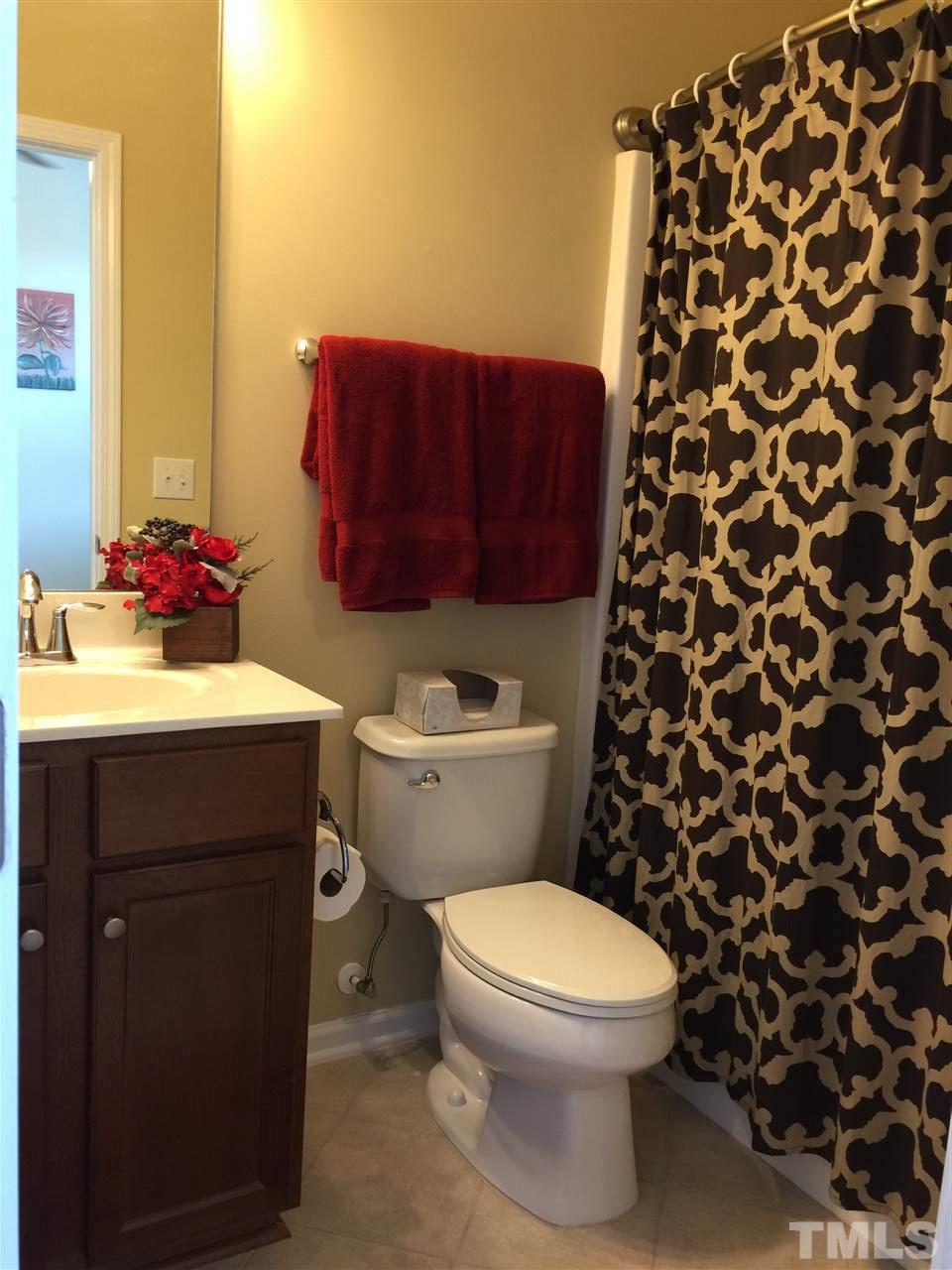 721 Wickham Ridge Road Apex, NC 27539 - Photo 17 of 25 a bathroom with a sink toilet and shower