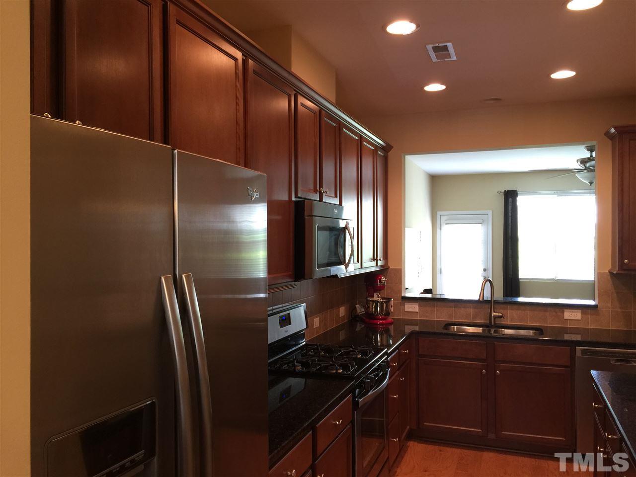 721 Wickham Ridge Road Apex, NC 27539 - Photo 6 of 25 a kitchen with a sink a refrigerator and wooden floor