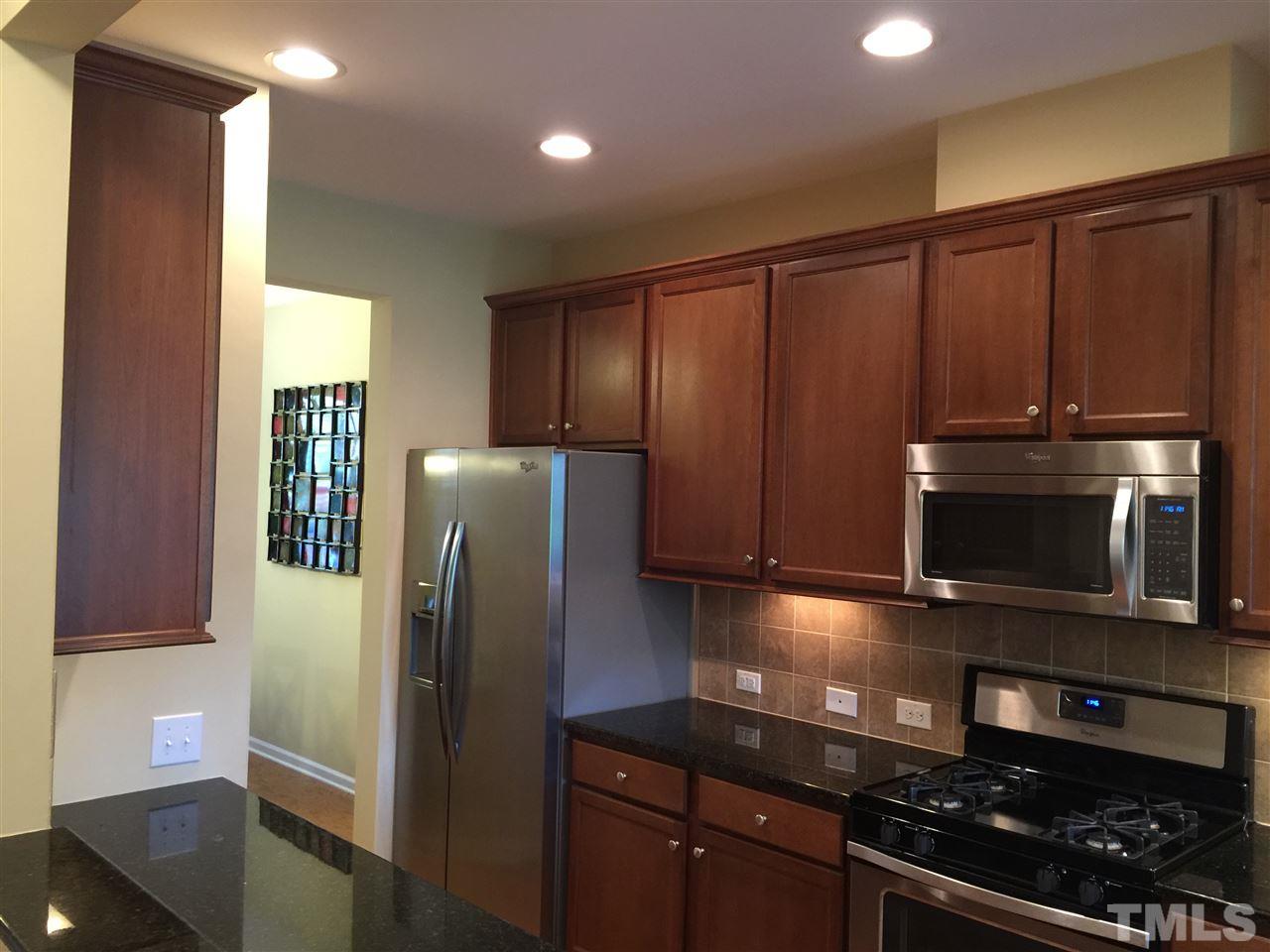 721 Wickham Ridge Road Apex, NC 27539 - Photo 8 of 25 a kitchen with stainless steel appliances granite countertop a refrigerator and a stove top oven