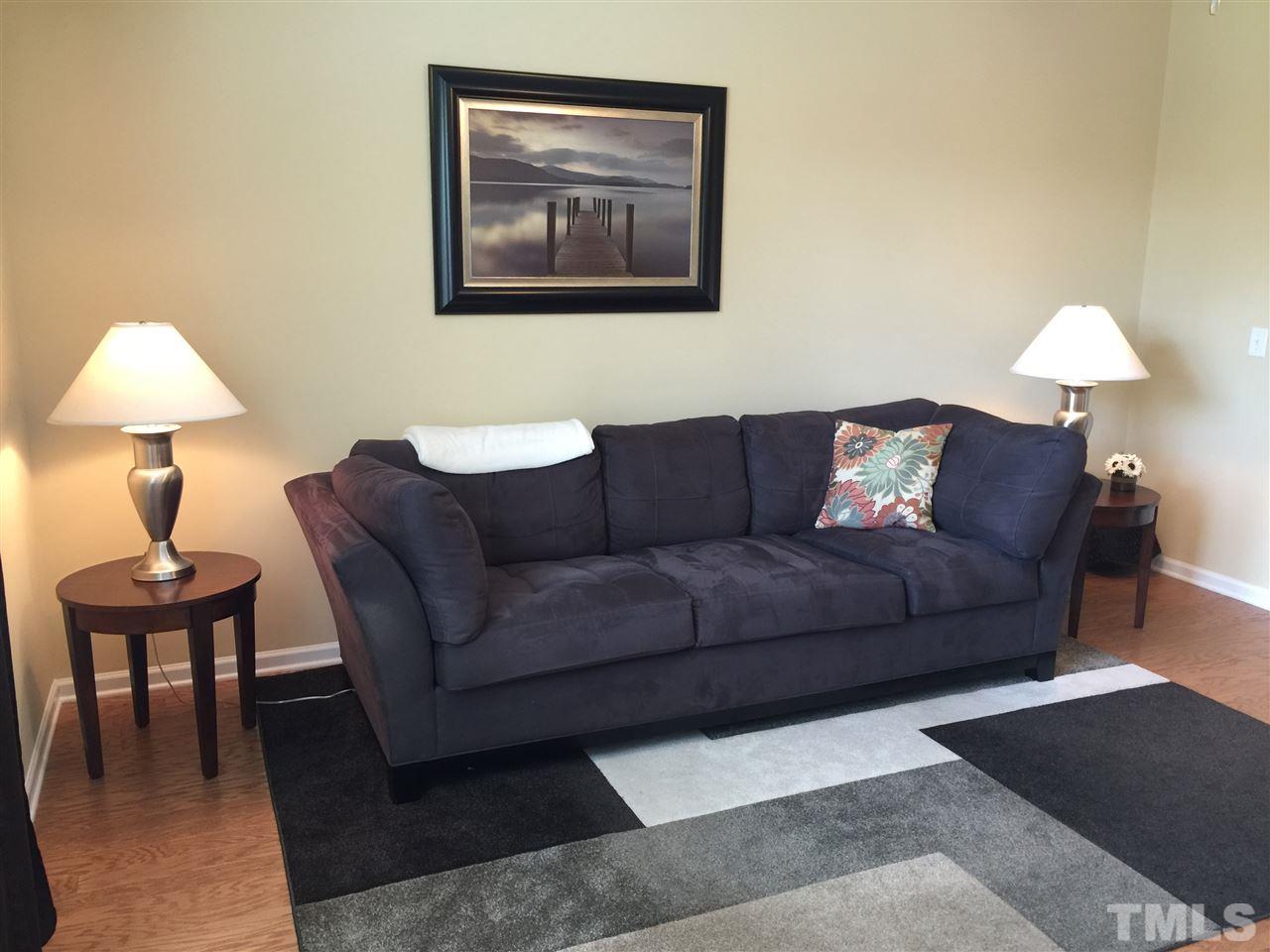 721 Wickham Ridge Road Apex, NC 27539 - Photo 9 of 25 a living room with furniture and a lamp