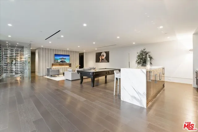 a view of a kitchen with kitchen island a stove a table and a refrigerator