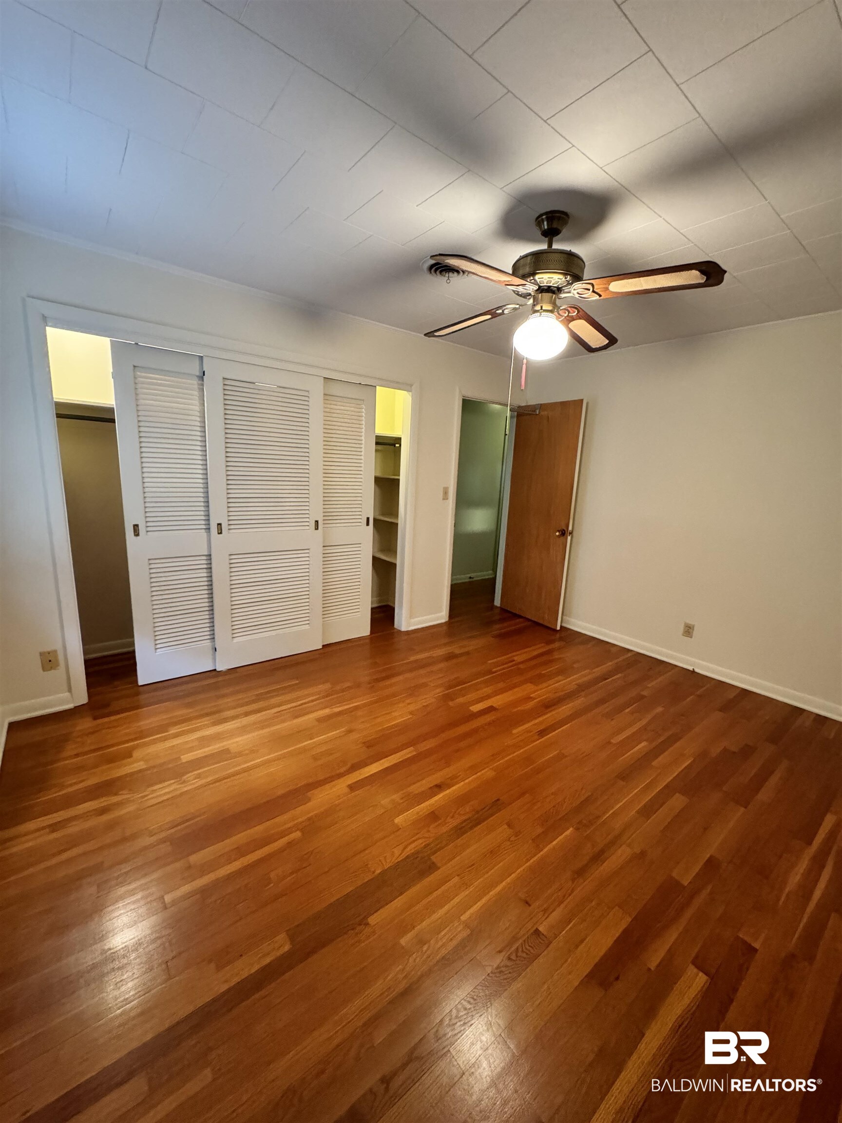 217 West Magnolia Avenue Foley, AL 36535 - Photo 14 of 21 Unfurnished bedroom featuring hardwood / wood-style flooring and ceiling fan