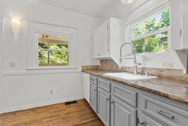 a kitchen with a granite countertop sink and window