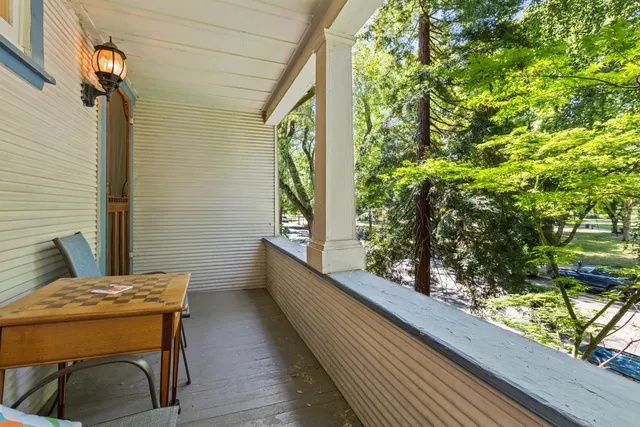 a balcony with wooden floor and outdoor seating
