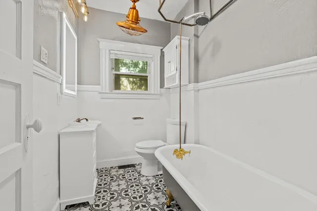 a bathroom with a bathtub a window and a shower