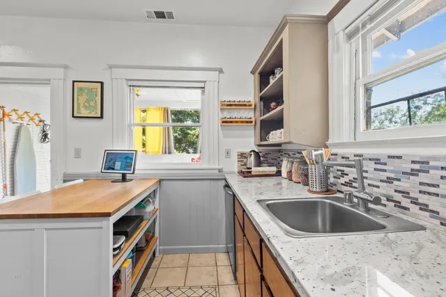 a kitchen that has a sink a stove and a table in it