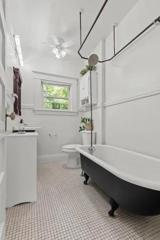 a bathroom with a sink a toilet a mirror and bathtub