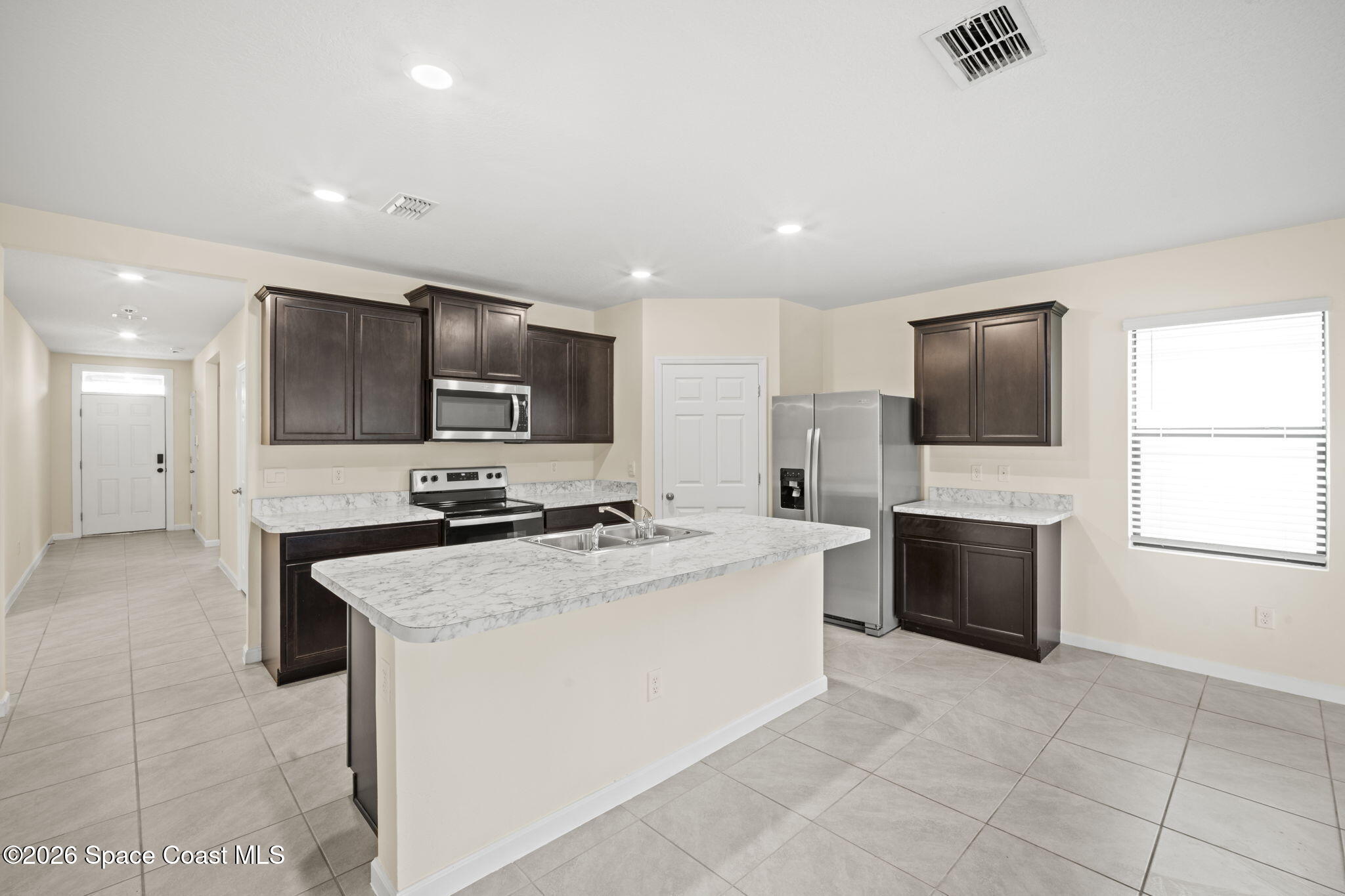 4412 Talbot Boulevard Cocoa, FL 32926 - Photo 12 of 32 a kitchen with stainless steel appliances a stove sink microwave refrigerator and cabinets