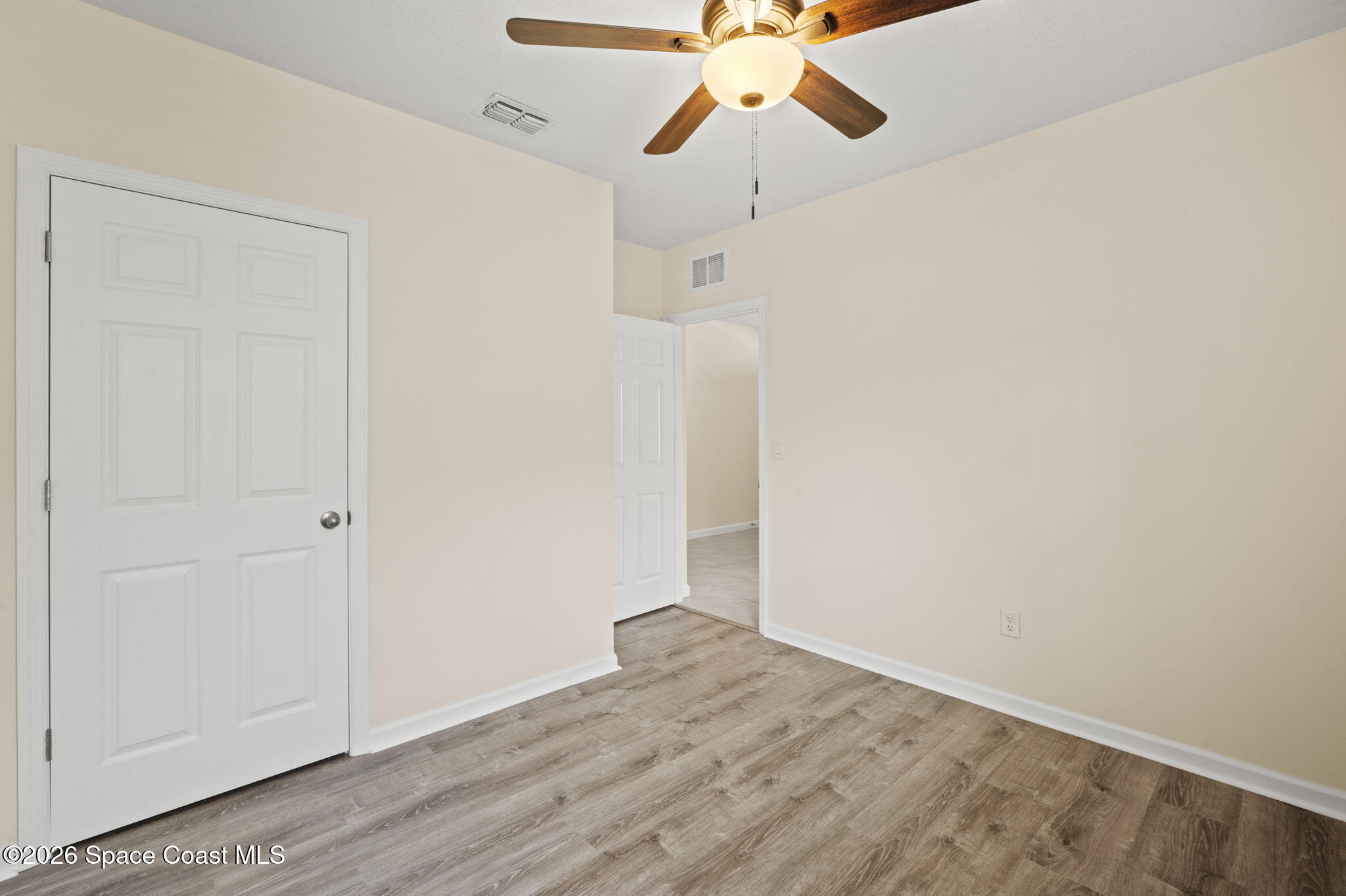 4412 Talbot Boulevard Cocoa, FL 32926 - Photo 22 of 32 an empty room with wooden floor fan and windows