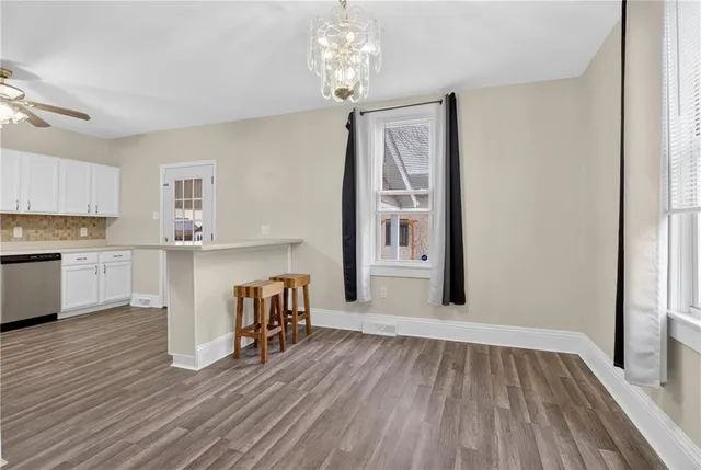 a view of a kitchen with cabinets and wooden floor
