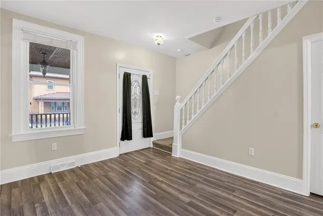 a view of an entryway with wooden floor and stairs