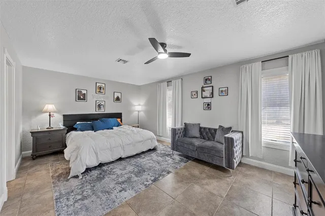 a bedroom with a large bed couch and a window