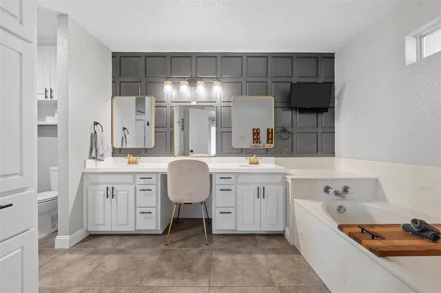 a large bathroom with a double vanity sink a mirror and a bathtub
