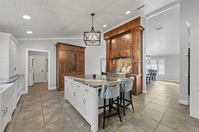 a large kitchen with kitchen island granite countertop a large counter top space appliances and cabinets