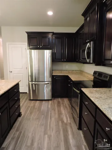 a kitchen with kitchen island granite countertop a sink stove and refrigerator