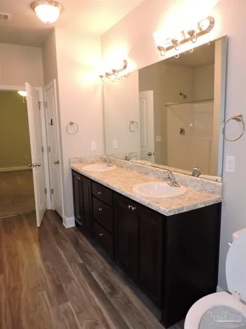 a bathroom with a granite countertop sink toilet and shower